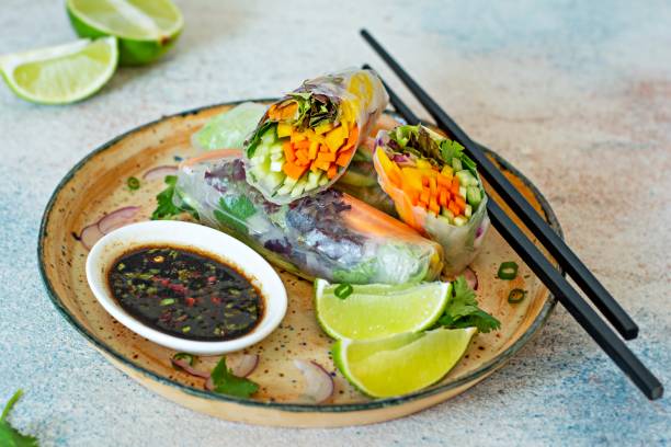 istock Fresh Asian appetizer Spring rolls (Nem) made from rice paper and raw vegetables and herbs with hot sauce on a light blue background. Vietnamese Food 1292477438