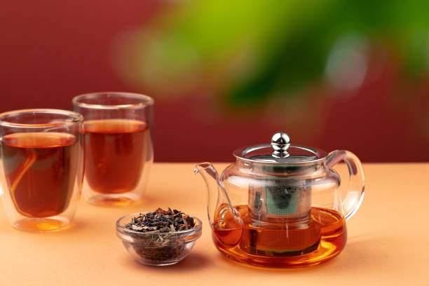 istock Glass teapot and two glass cups with tea 1292478137