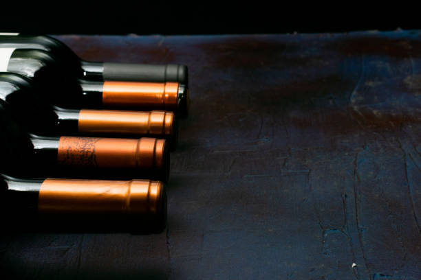 istock Top of wine bottles uprigth on dark background 1292485689