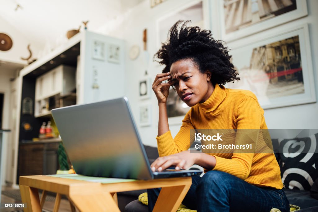 African American woman working from home Stressed out African American female freelancer working from home using her laptop and encountering some problems concerning her business One Woman Only Stock Photo