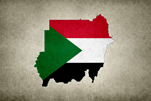 Grunge map of Sudan with its flag printed within its border on an old paper.