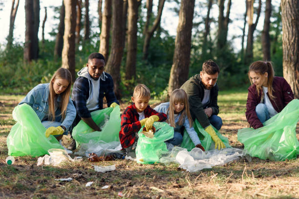 istock Group of international multi aged volunteers keep nature clean and picking up garbage from the forest. Ecology concept. 1292487452