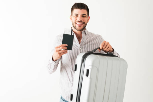 istock Happy latin man is holding a plane ticket and a suitcase 1292488358