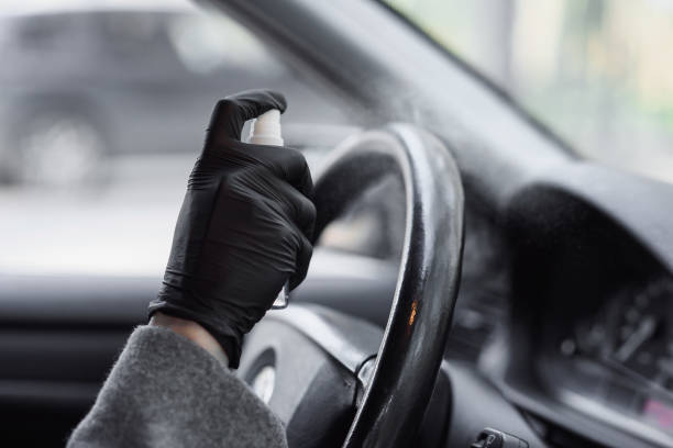 istock Cleansing car interior and spraying with disinfection liquid. Hands in rubber protective glove disinfecting vihicle inside for protection from virus disease 1292489315