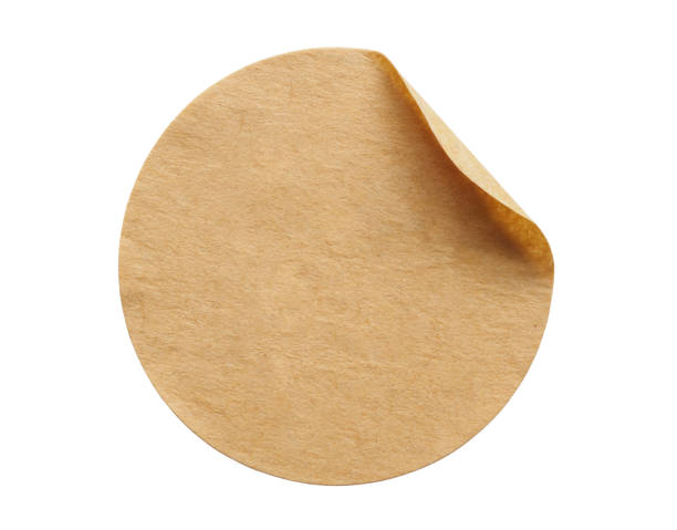 istock Brown round paper sticker label isolated on white background 1292492478