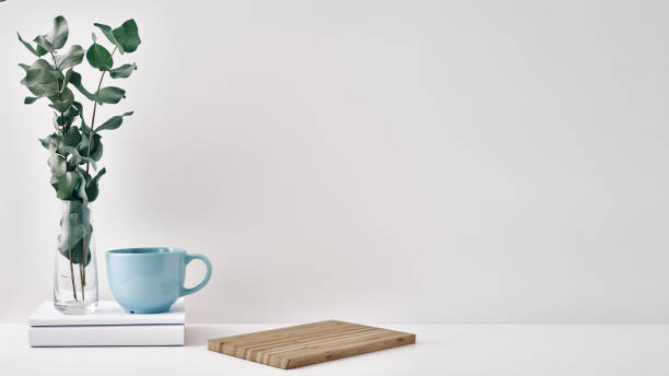 istock A mug, a stack of books, a wooden board and a transparent vase with eucalyptus branches. Eco-friendly materials in interior decor, minimalism. Copy space, mock up 1292492494