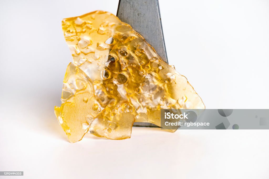 Cannabis oil concentrate aka shatter isolated over white Macro detail of cannabis oil concentrate aka shatter isolated over white background Marijuana - Herbal Cannabis Stock Photo