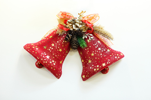 Two red bells isolated on a bright Christmas background