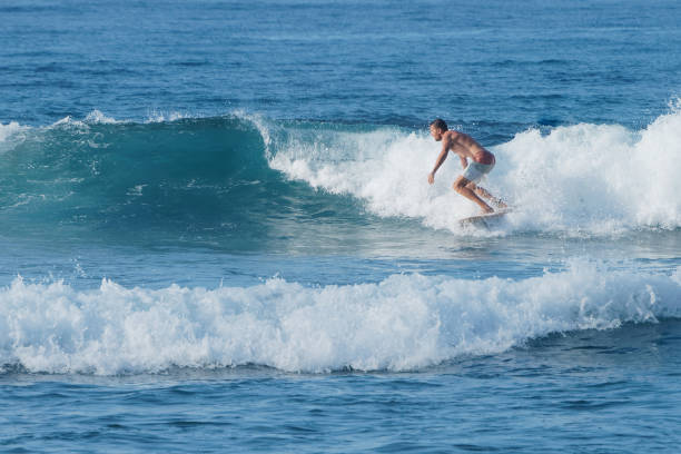 istock Surfer goes left in small wave in ocean. Tropical wave. 1292497341