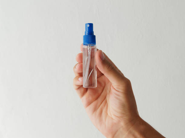 istock Hand holds alcohol spray bottle. Close up alcohol spray. Killing the virus. 1292497342