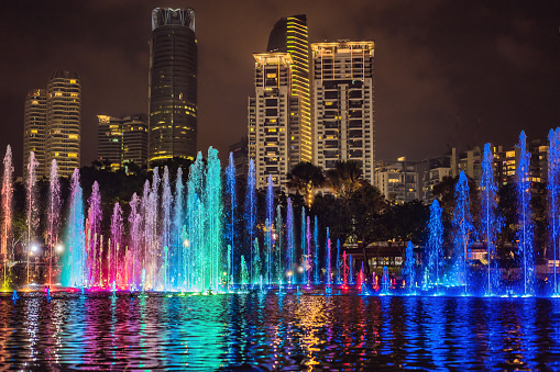 The colorful fountain on the lake at night, near by Twin Towers with city on background. Kuala Lumpur, Malaysia.