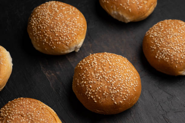 istock Burger bun bread with sesame seeds on dark background 1292501563