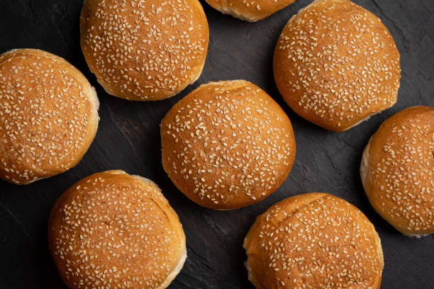 istock Burger bun bread with sesame seeds on dark background 1292501648