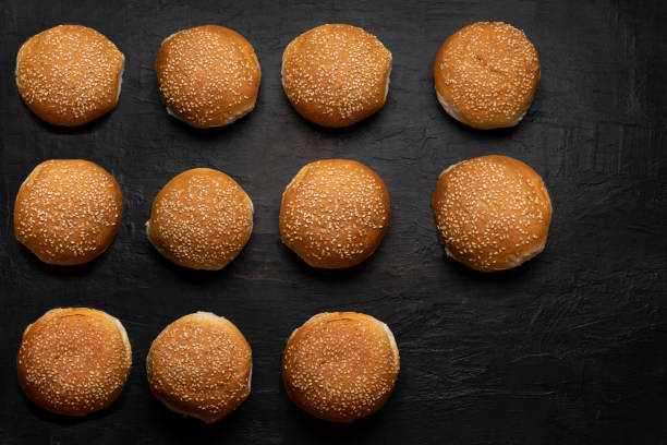 istock Burger bun bread with sesame seeds on dark background 1292502429