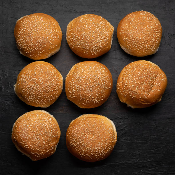 istock Burger bun bread with sesame seeds on dark background 1292502572