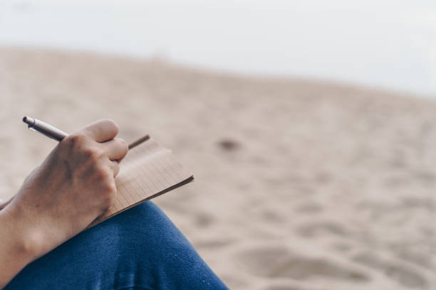 istock Woman hand writing down in small white memo notebook for take a note not to forget or to do list plan for future. 1292514187