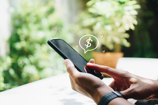 Mujer utilizar gadget teléfono inteligente móvil ganar dinero en línea con el icono de dólar pop-up. Tecnología fintech de negocios en concepto de smartphone. photo