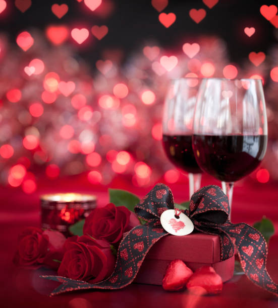 istock Valentine's Day Red Roses and Red Wine with a Gift on a Defocused Lights Background 1292517513