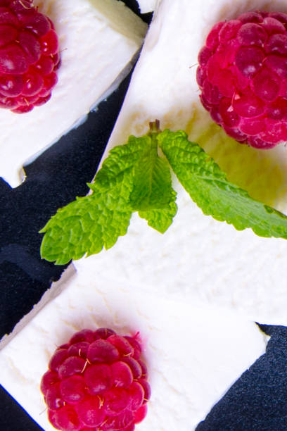 crème glacée avec des lames de menthe de baies de framboise sur un fond noir, plan rapproché - raspberry ice cream close up fruit mint photos et images de collection