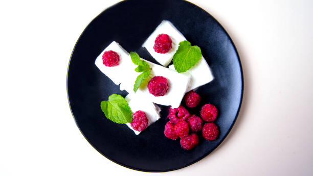 istock Ice cream with raspberry berries, mint leaves on a black plate, white background, place for text 1292519890