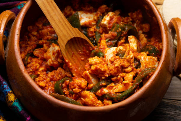 istock Mexican scrambled eggs in red sauce with poblano pepper and cheese on wooden background 1292519897