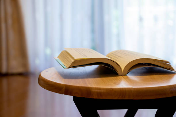 istock Opened book on the wooden desk 1292519927