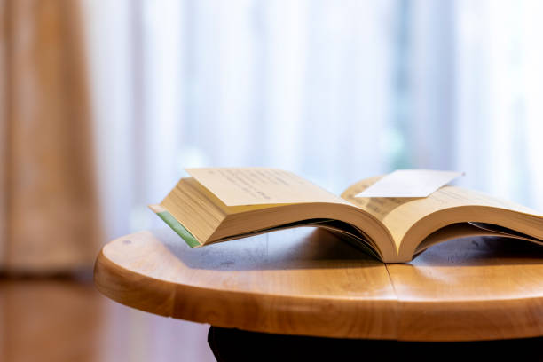 istock Opened book on the wooden desk 1292519948
