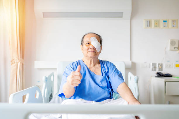Treatment of post-operative cataract by the concept Treatment of post-operative cataract by the concept of caregiver An old Asian man put a protective shield over her eyes to cover the cover to protect during nap time. cornea stock pictures, royalty-free photos & images