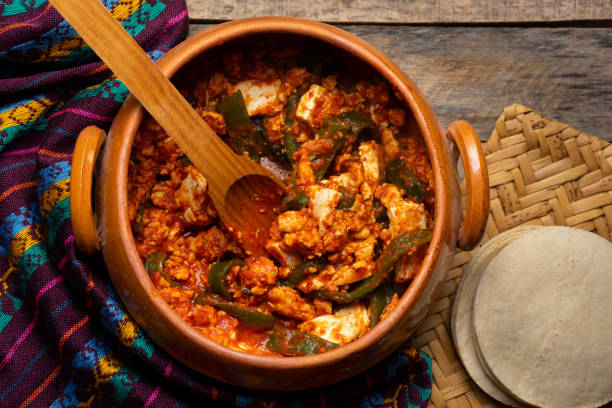 istock Mexican scrambled eggs in red sauce with poblano pepper and cheese on wooden background 1292520956
