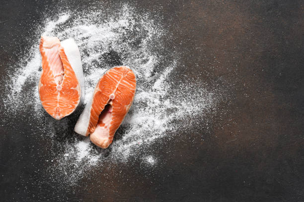 bistecca di salmone con sale su un tavolo da cucina in cemento. vista dall'alto con spazio di copia. - salmon fillet prepared fish cross section foto e immagini stock