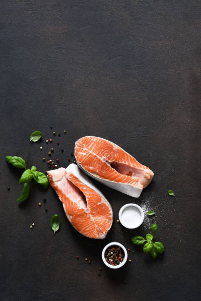 bistecca di salmone con spezie su un tavolo da cucina in cemento. vista dall'alto con spazio di copia. - salmon fillet prepared fish cross section foto e immagini stock