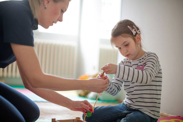 istock Girl practicing fine motor skills with female tutor 1292526549
