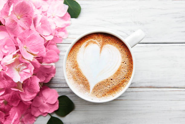 istock Beautiful hydrangea flowers and coffee cup on rustic white wood, flat lay. 1292530474