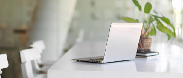 istock Portable workspace with laptop, plant pot and stationery in co-working space 1292532262