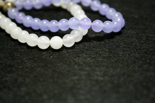 istock White and purple bracelets on a black felt background. 1292533014