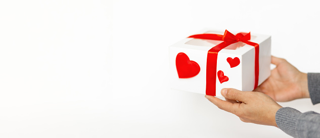 Cropped Hands Of Man Giving Gift white Box with red hearts To Woman, Valentines Day concept, 8 march womans day.White background,copy space