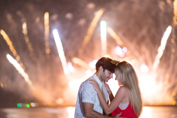 Young couple enjoy firework during celebration festival on the beach.