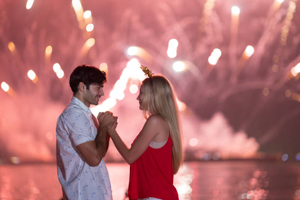 istock Young couple enjoy firework during celebration festival on the beach. 1292533102