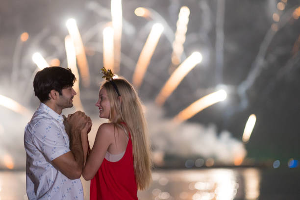 istock Young couple enjoy firework during celebration festival on the beach. 1292533138