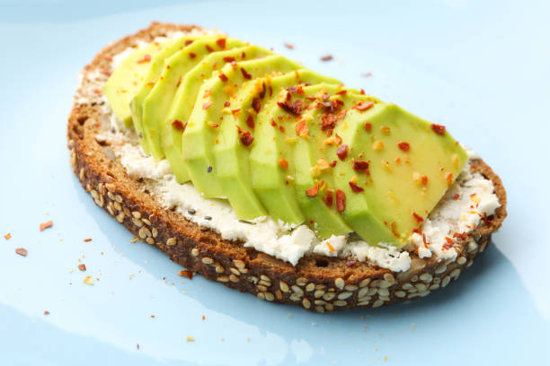 istock Delicious toast with avocado on white background 1292534821
