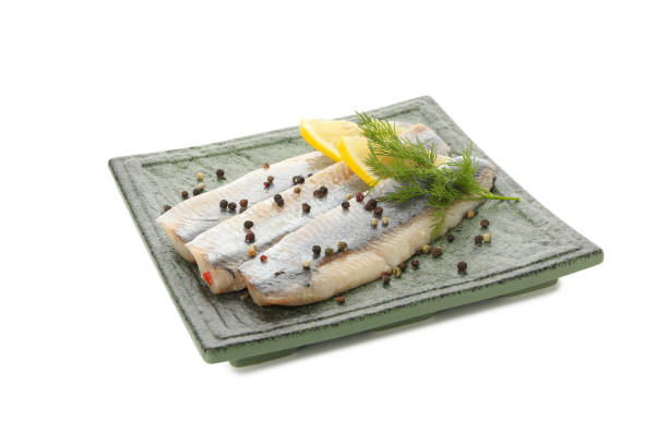 istock Plate with herring fish slices and spices isolated on white background 1292535849
