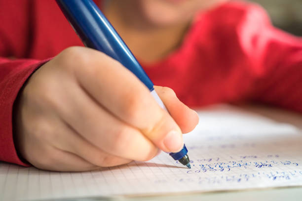 Elementary school age child practices arithmetic while solving math problems homeschooling fountain pen pattern writing instrument pen stock pictures, royalty-free photos & images