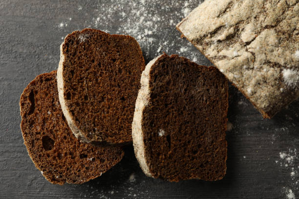 istock Fresh baked rye bread and flour on black background 1292536413