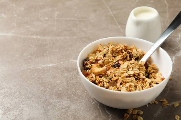 istock Bowl with granola and milk on gray background 1292538653