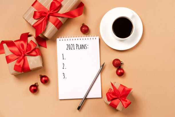 istock Holiday gifts boxes notepad for writing plans coffee cup on a brown background 1292539182