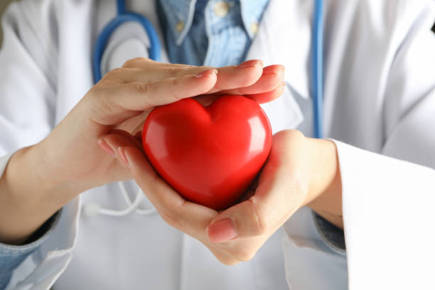 istock Female doctor with stethoscope holding red heart 1292539449