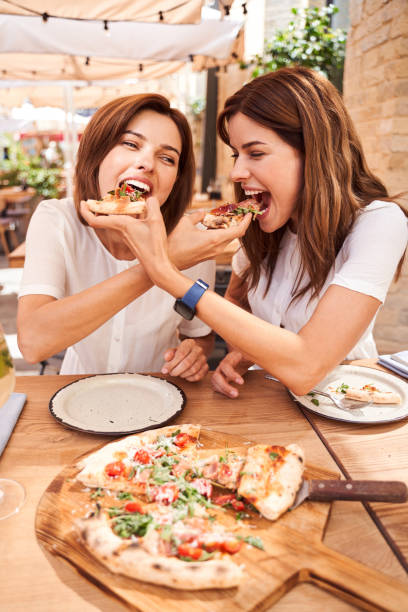 istock Girls feeding each other with pizza 1292539993