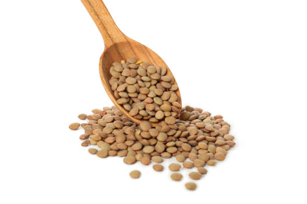 istock Wooden spoon with legumes isolated on white background 1292540163