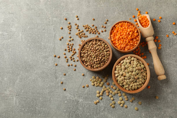istock Scoop and bowls with different legumes on gray background 1292540413