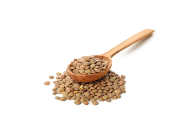 istock Wooden spoon with legumes isolated on white background 1292540590